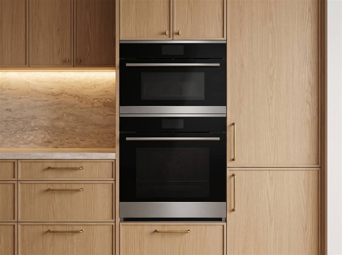 Built-in wall oven and steam oven stacked in green cabinetry